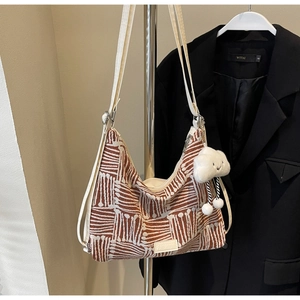 Close-up of large striped canvas tote bag featuring cloud pendant and FASHION leather tag