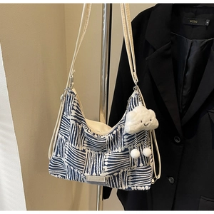 Detail of blue and white striped canvas tote bag with soft plush cloud charm