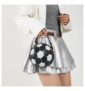 Modische Fußball-Handtasche mit Goldakzenten kombiniert mit einem metallischen Faltenrock