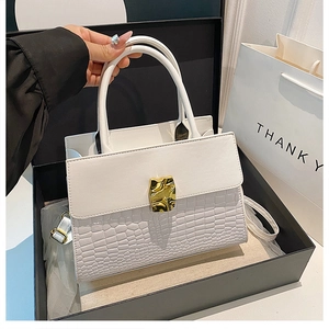 Chic white crocodile-embossed handbag displayed in a luxury black gift box with gold buckle