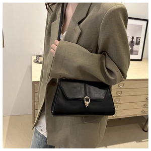 Détail d'un sac à bandoulière noir en similicuir avec boucle dorée minimaliste