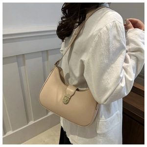 Detail of minimalist cream half-moon bag with elegant golden twist-lock closure