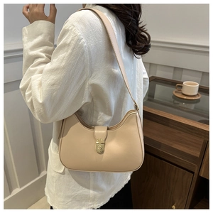 Chic beige half-moon hobo bag worn by a model in a stylish indoor lifestyle setting