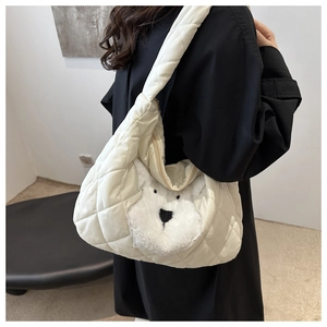 Detailed view of white quilted tote bag featuring a cute plush dog patch and wide strap