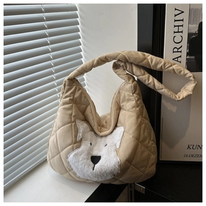 Detailed view of beige quilted tote bag with cute plush schnauzer dog patch and zipper