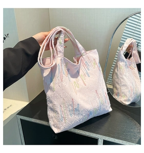 Detail shot of colorful gradient wave embroidery and monogram pattern on tote bag