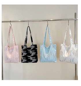 Detailed display of tote bags in pink, black, blue, and white with wavy textured patterns