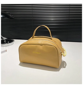 Détail du sac à main jaune en cuir grainé avec fermeture éclair à cordon tissé
