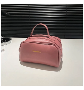 Détail du sac rose en cuir PU grainé avec fermeture éclair et poignée large pratique