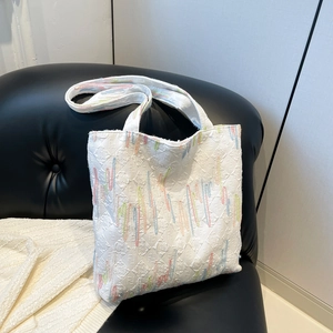 Rainbow striped tote bag with colorful embroidery and white embossed pattern