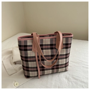Detailed close-up of pink plaid tote bag texture and reinforced leather shoulder straps