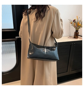 Chic black pillow bag with silver star ornament and sleek shoulder strap detail