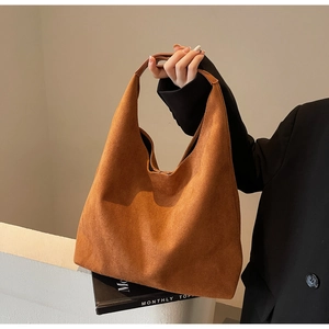 Close-up of a large dark brown suede tote bag with a minimalist hobo slouch design