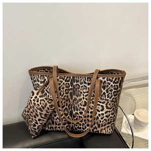Close-up of leopard print tote bag with brown leather handles and matching pouch