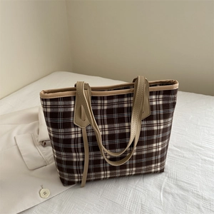 Classic brown and white checkered tote bag with cream handles in a minimalist interior setting