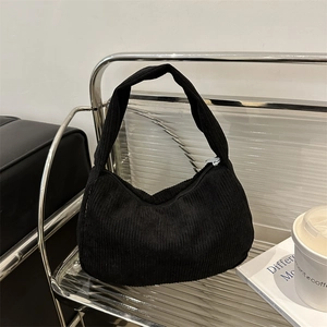 Elegant black corduroy hobo shoulder bag for women on a sleek metal stand display