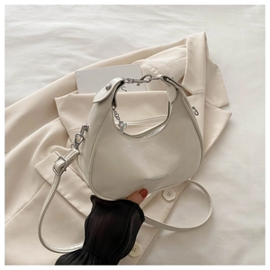 Close-up of white crescent bag with leather texture and FASHION & BAGS logo detail