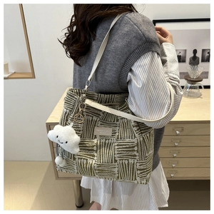Detail of green and white striped tote bag with PU strap and cloud charm accessory