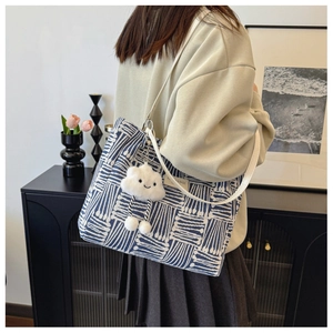 Detail of blue and white striped canvas tote bag with a cute white plush cloud charm