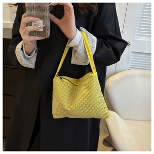 Gelbe Handtasche mit silbernen Strasssteinen kombiniert mit einem schwarzen Mantel