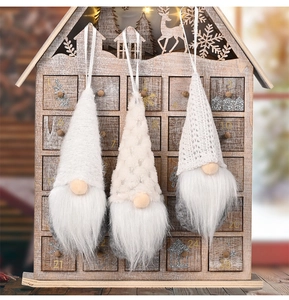 Detailed view of three Nordic Christmas gnomes with knit hats on a wooden advent calendar