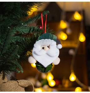 Détail du Père Noël en peluche avec clochette verte en métal sur le sapin de Noël