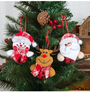 Close-up of Christmas ornaments with snowmen and reindeer hanging on a pine tree