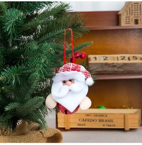 Detail of Santa Claus bell ornament with red plaid hat hanging on a Christmas tree