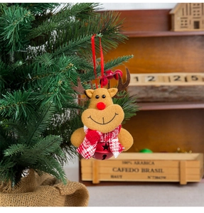 Detail of reindeer plush ornament with red bell hanging on a Christmas tree branch