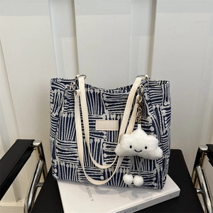 Blue and white geometric striped tote bag with leather straps and cloud charm
