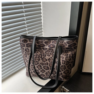 Close-up of leopard print fabric and black leather strap on a large tote bag