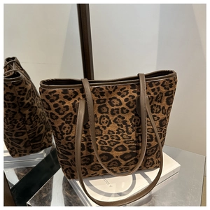 Detail of leopard print tote bag with brown leather straps and spacious interior
