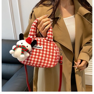 Detail of red and white checkered handbag featuring a cute plush puppy Christmas pendant
