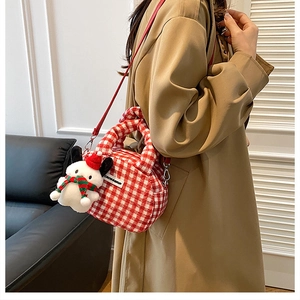 Detail of red and white checkered plush bowling bag with cute Christmas dog charm