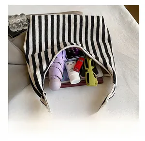 Intérieur spacieux du sac cabas en toile à rayures noires et blanches avec accessoires