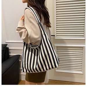 Close-up of black and white striped canvas tote bag showing thick texture and hobo style