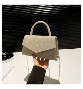 Detail of champagne gold glitter evening bag with envelope flap and metal chain handle