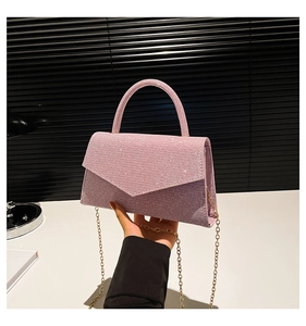 Detail of pink glitter crossbody bag with round handle and gold chain strap