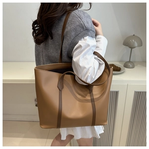 Detail of a large brown tote bag in a lifestyle setting showing its spacious capacity