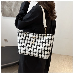 Détail du sac cabas à carreaux avec pendentif cerf doré et bandoulière en similicuir blanc