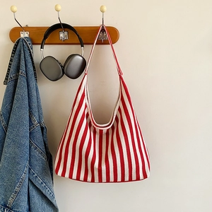 Vue détaillée du sac cabas en toile à rayures rouges et blanches suspendu à un crochet