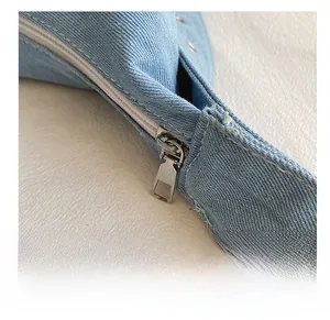 Gros plan détaillé de la fermeture éclair argentée sur le sac cabas en denim bleu clair