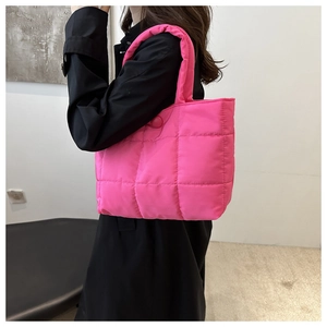 Détail du sac fourre-tout matelassé rose vif montrant sa texture et sa bandoulière