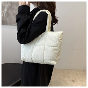 Détail du sac cabas matelassé blanc avec motifs à points larges et fermeture bouton