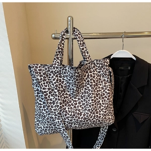 Detailed view of leopard print canvas tote bag with dual handles and long shoulder strap