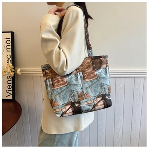 Detailed view of the vintage denim print and leather patch on the canvas tote bag