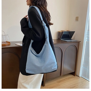 Détail du sac cabas en denim bleu clair avec bandoulière réglable à œillets