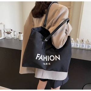 Detail of large black canvas tote bag with leather straps and Fashion Paris print