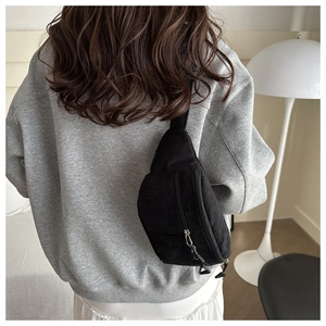 Gros plan sur le sac de poitrine en velours côtelé noir avec sangle réglable et zip