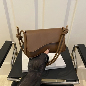 Sac bandoulière en cuir marron avec rabat ondulé et bandoulière décorative à nœuds